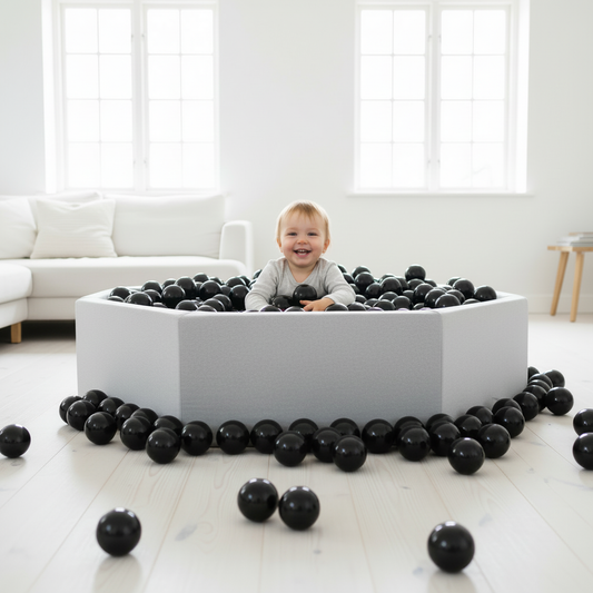 Kind in ballenbak zwarte ballen lichte kamer ingezoomd